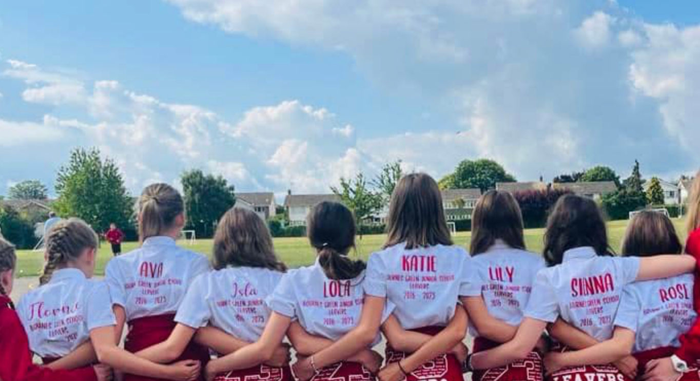 Group of children wearing personalised Bournes Green Junior School leavers shirts with their names, school and on the years spent at the school on the back.