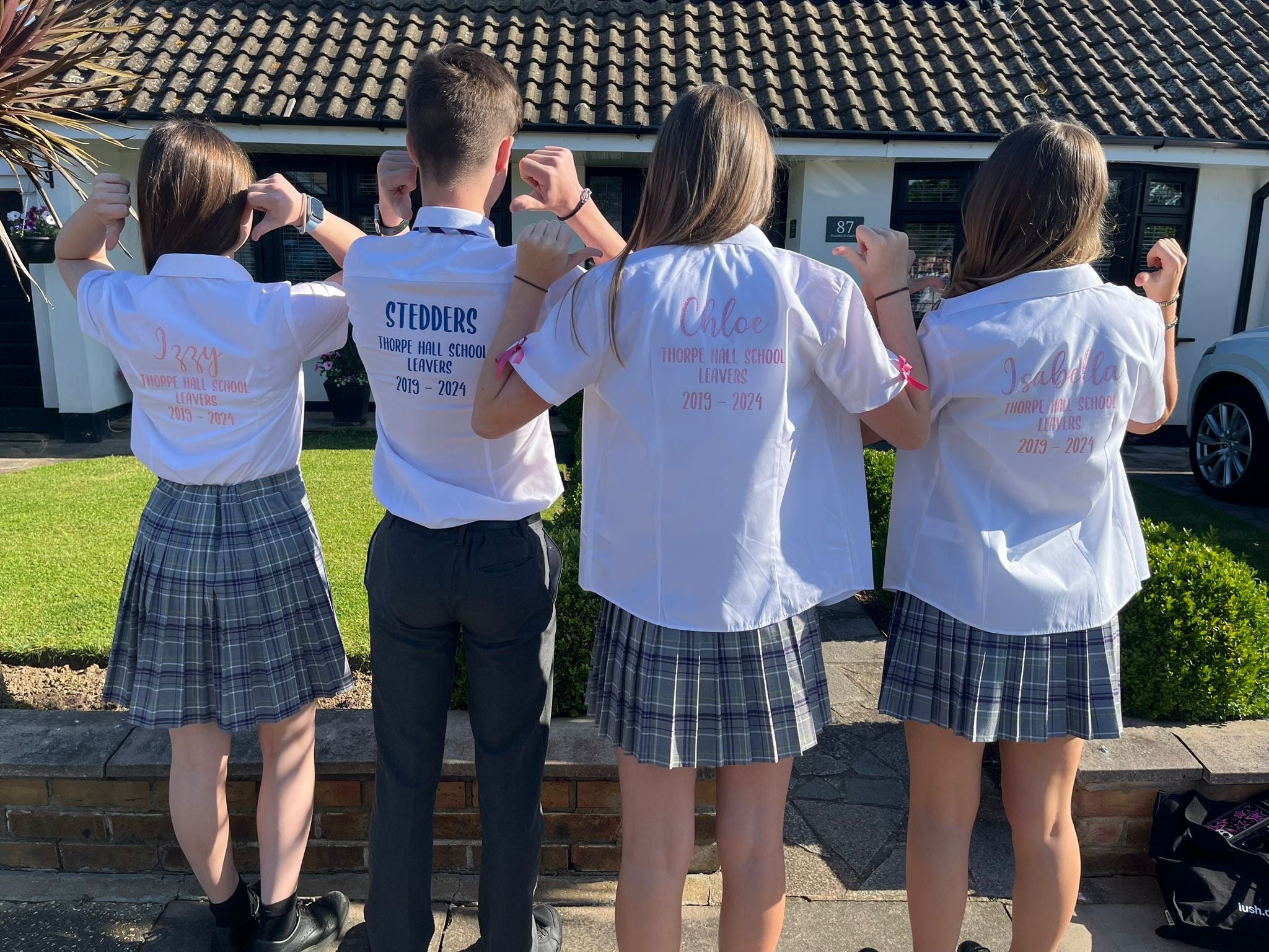 Group of children wearing personalised Thorpe Hall School leavers shirts.